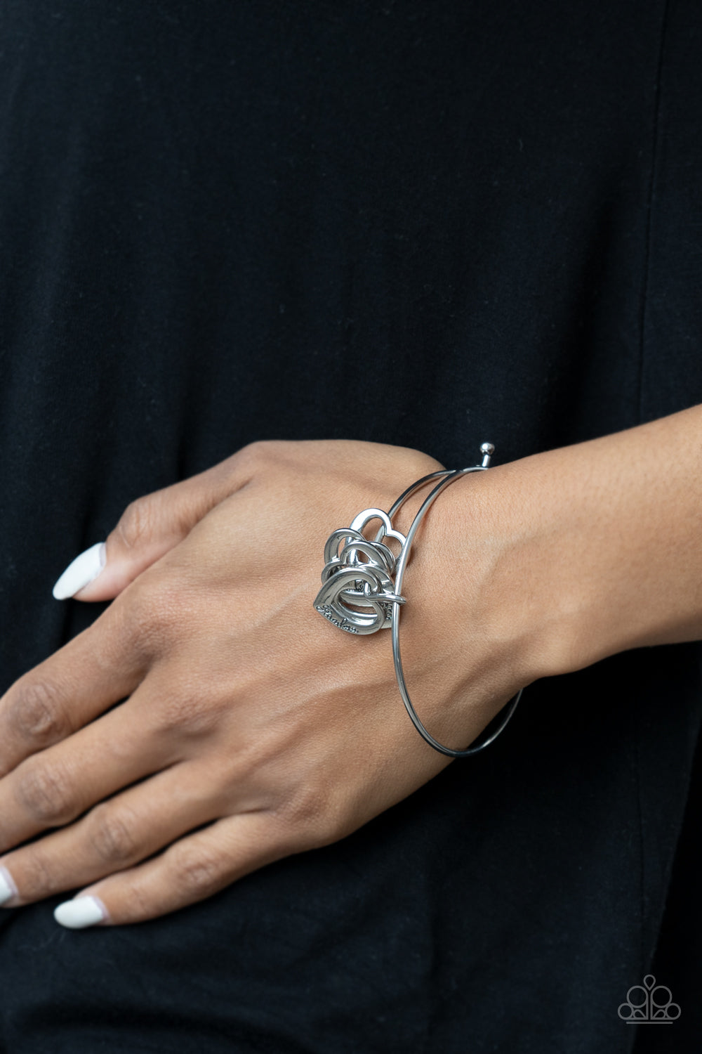 A glistening collection of airy silver heart charms that are stamped in the words, "grandma," "sister," "aunt," "daughter," and "mom," glide along the center of a silver bangle-like bracelet. Features a pronged closure. Sold as one individual bracelet.